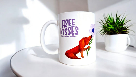 Mok met lila tekst “free kisses may contain slobber” met een bruine teckel op die een lila bloem vast heeft