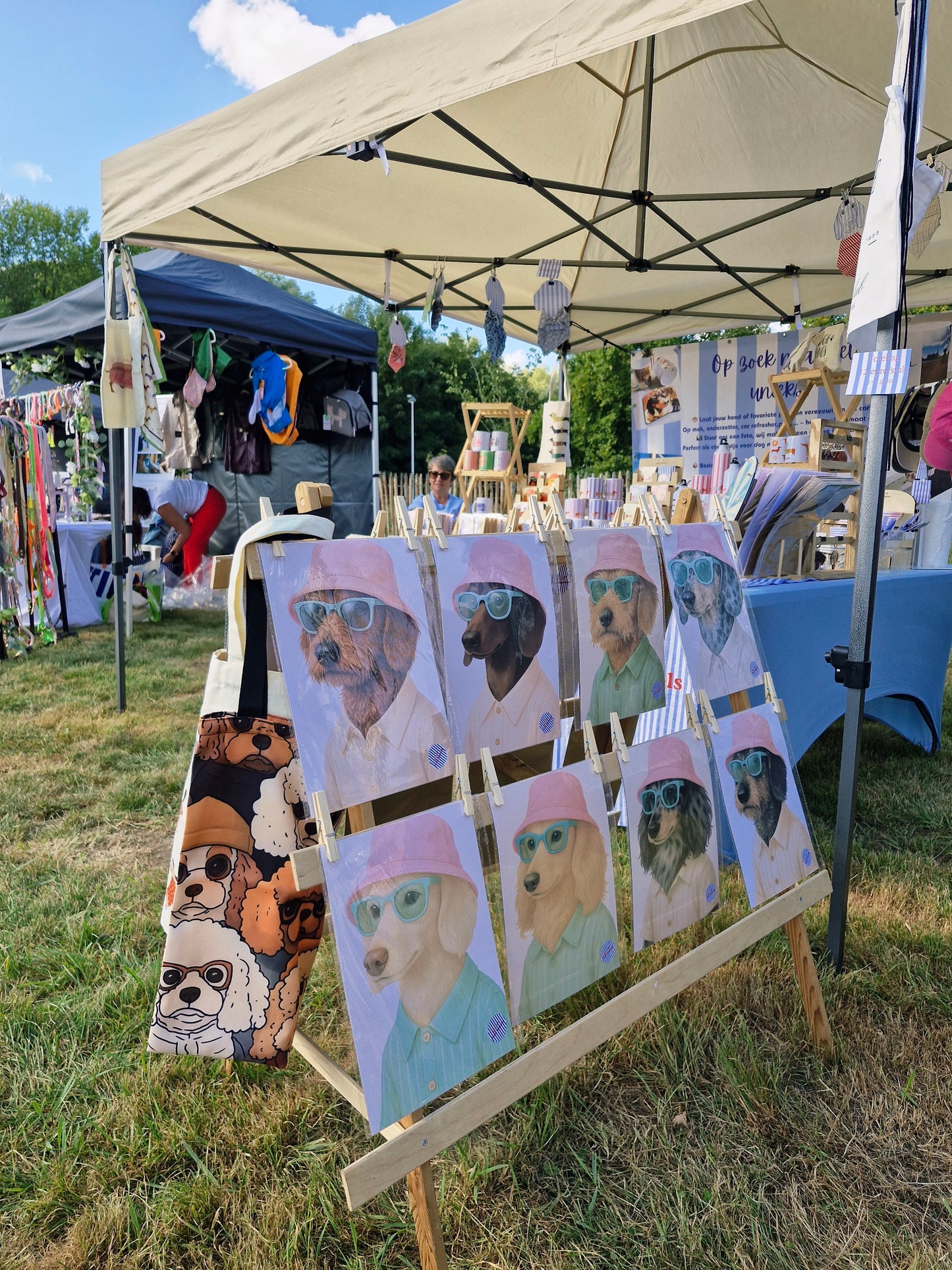 zicht met verschillende prints met teckels met roze zonnehoedjes op die te koop zijn op een hondenfestival