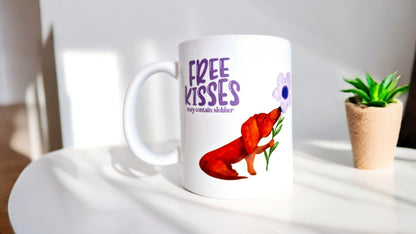 Mok met lila tekst “free kisses may contain slobber” met een bruine teckel op die een lila bloem vast heeft