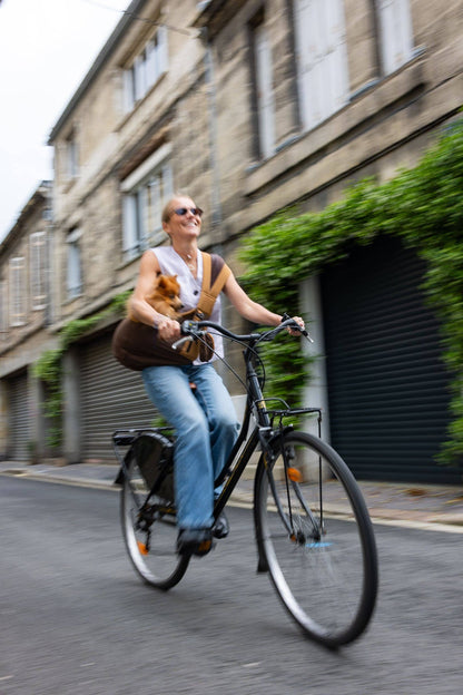 Fietsen met een teckel in de bruine hondendraagtas met schouderriem