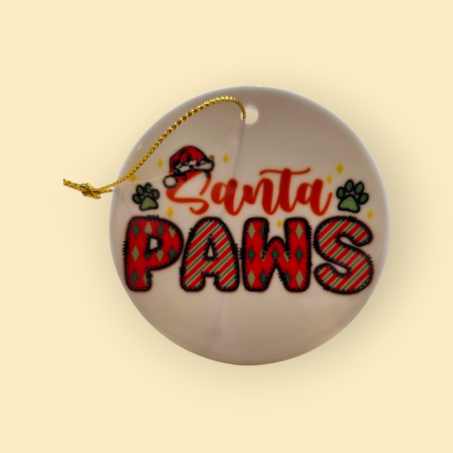 keramisch kerstornament met de tekst Santa Paws in de kleuren rood en groen, met groene pootjes erbij op