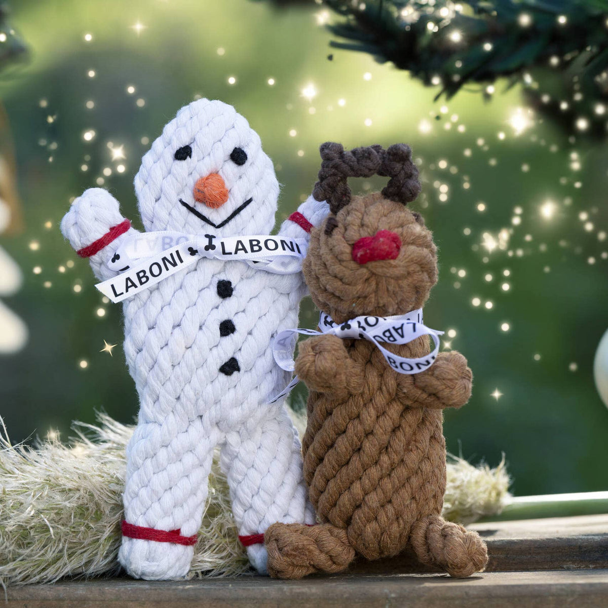 Rendier hondenspeeltje van touw naast een sneeuwpop speeltje in kerstsfeer