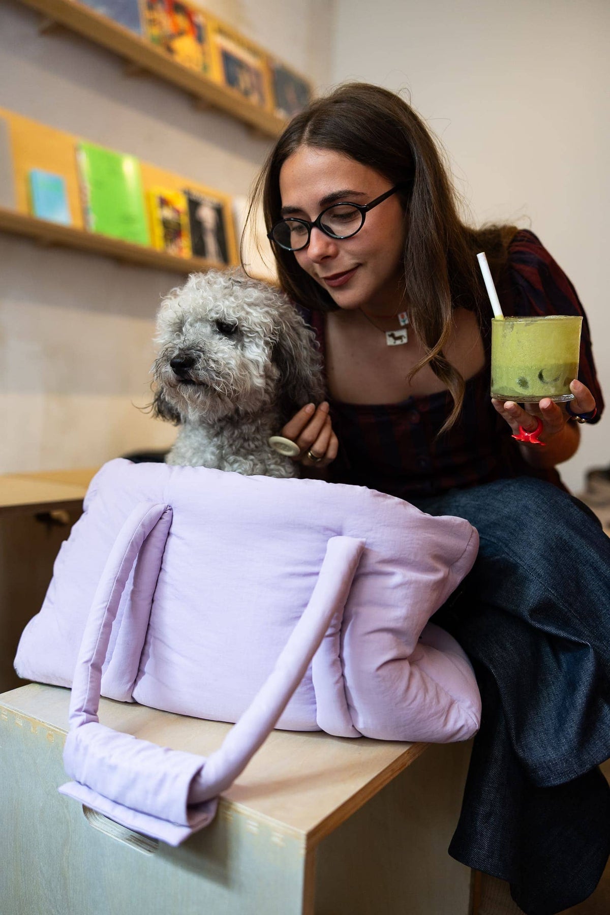 Vrouw aan tafel met poedel in de lila hondendraagtas voor teckel