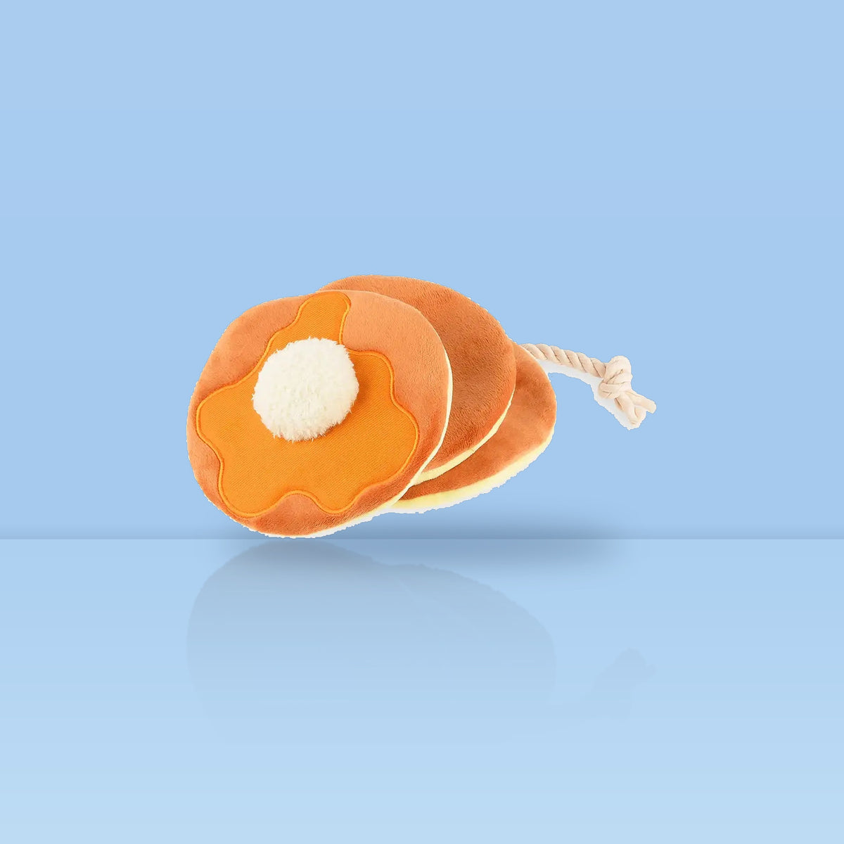 Stapel van drie pluche pannenkoeken met boter aan een touw als hondenspeeltje van P.L.A.Y.