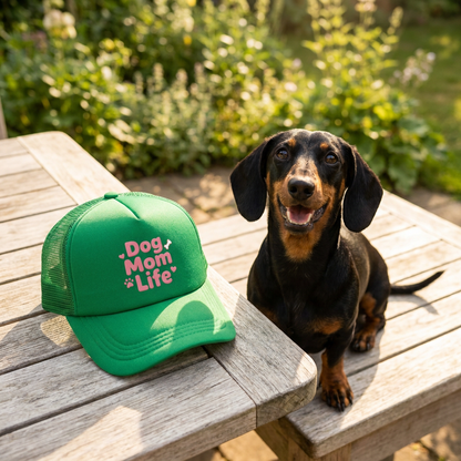 Groene trucker cap 'Dog Mom Life' op tafel naast teckel in de tuin