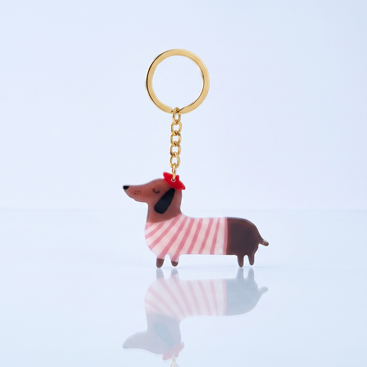 Acryl sleutelhanger teckel Parisienne roze op blauwe studio-achtergrond