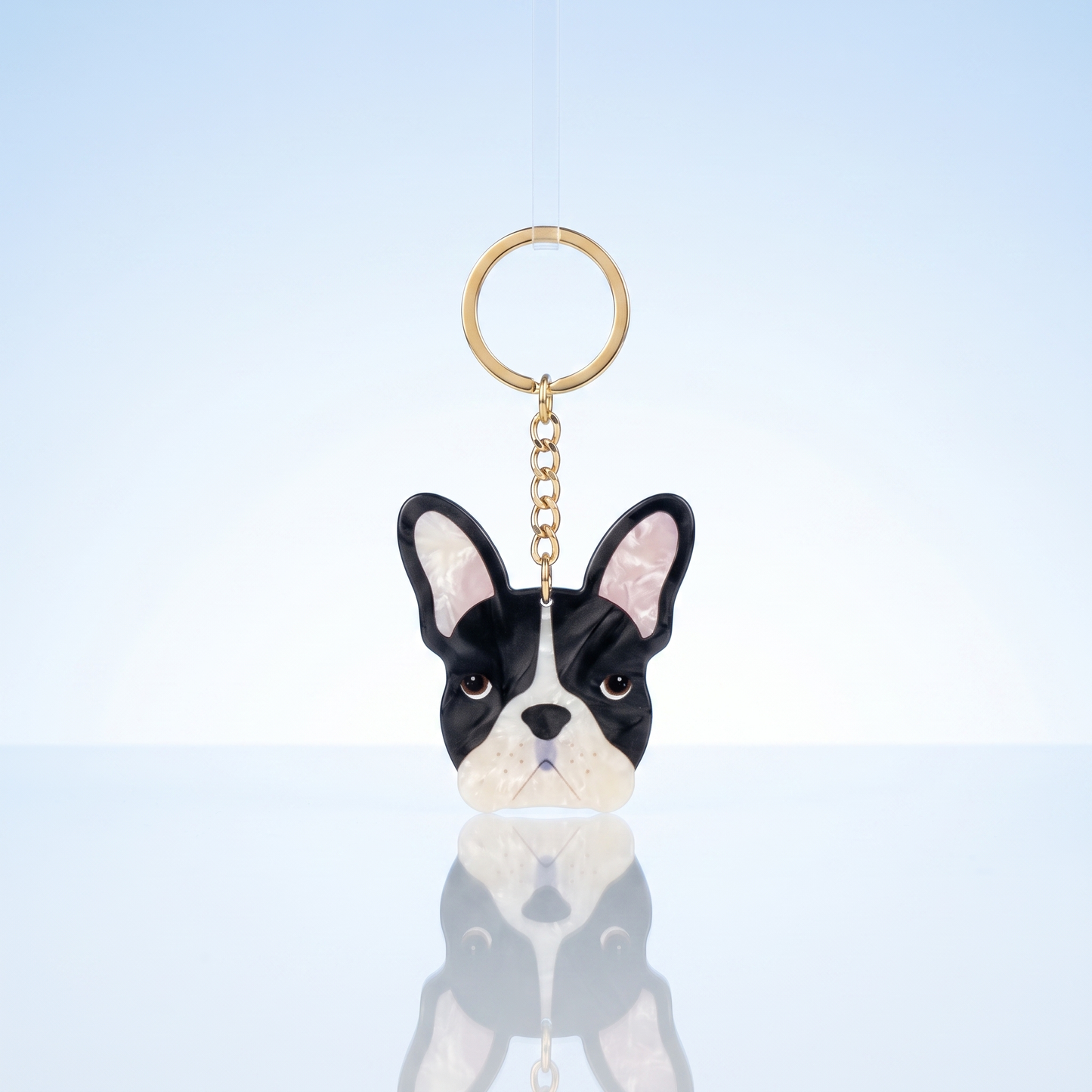 Acryl sleutelhanger Franse bulldog op blauwe studio-achtergrond