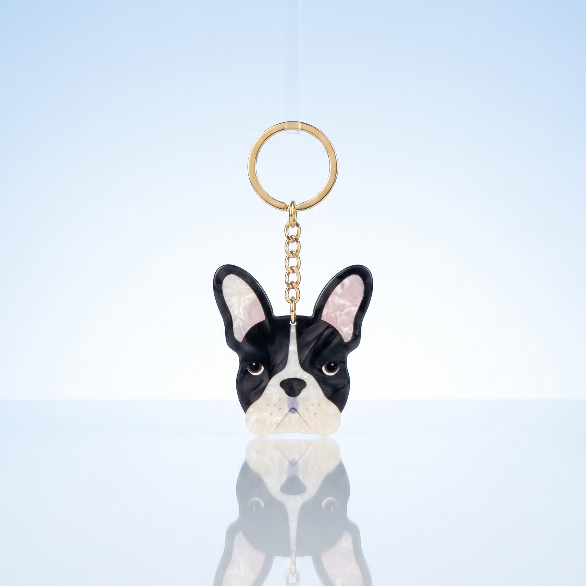 Acryl sleutelhanger Franse bulldog op blauwe studio-achtergrond