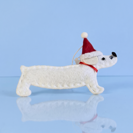 Wit vilten teckel kerstornament met kerstmuts op blauwe achtergrond, voor teckelliefhebbers