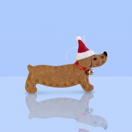 Bruin vilten teckel kerstornament met kerstmuts op blauwe achtergrond, voor teckelliefhebbers