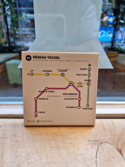 Teckel tegeltje met Parijse metrokaart rechtop op houten vensterbank