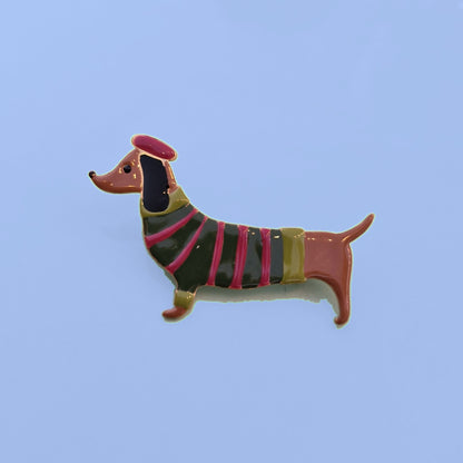 Emaille teckel broche met groen-roze gestreept truitje en fuchsia baret
