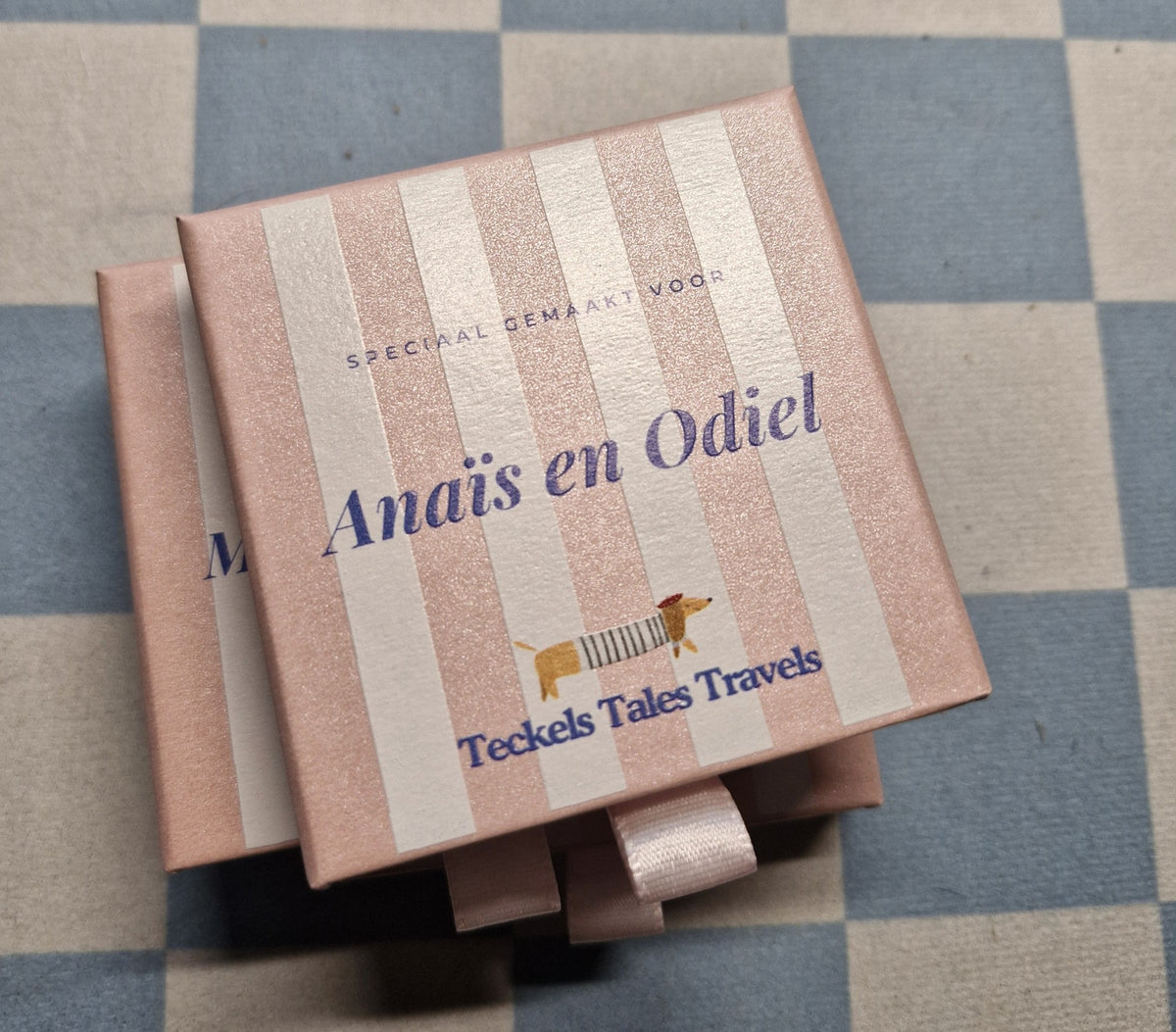 Roze gestreepte cadeaudoosjes van Teckels Tales Travels met de namen van de honden erop geprint